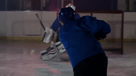 Professional-athlete-male-hockey-player-turns-in-front-of-the-camera-with-a-puck-and-strikes-the-opponent's-goal-and-scores